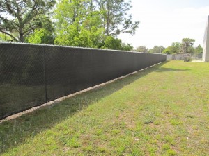 While school security experts typically recommend that fencing for schools permit open viewing to reduce crime, there are exceptions.  Because this Florida school serves a number of autistic children and has a swamp located next to this side of the school, the installation of screening materials to conceal the water is both logical and prudent as many autistic children are attracted to bodies of water.